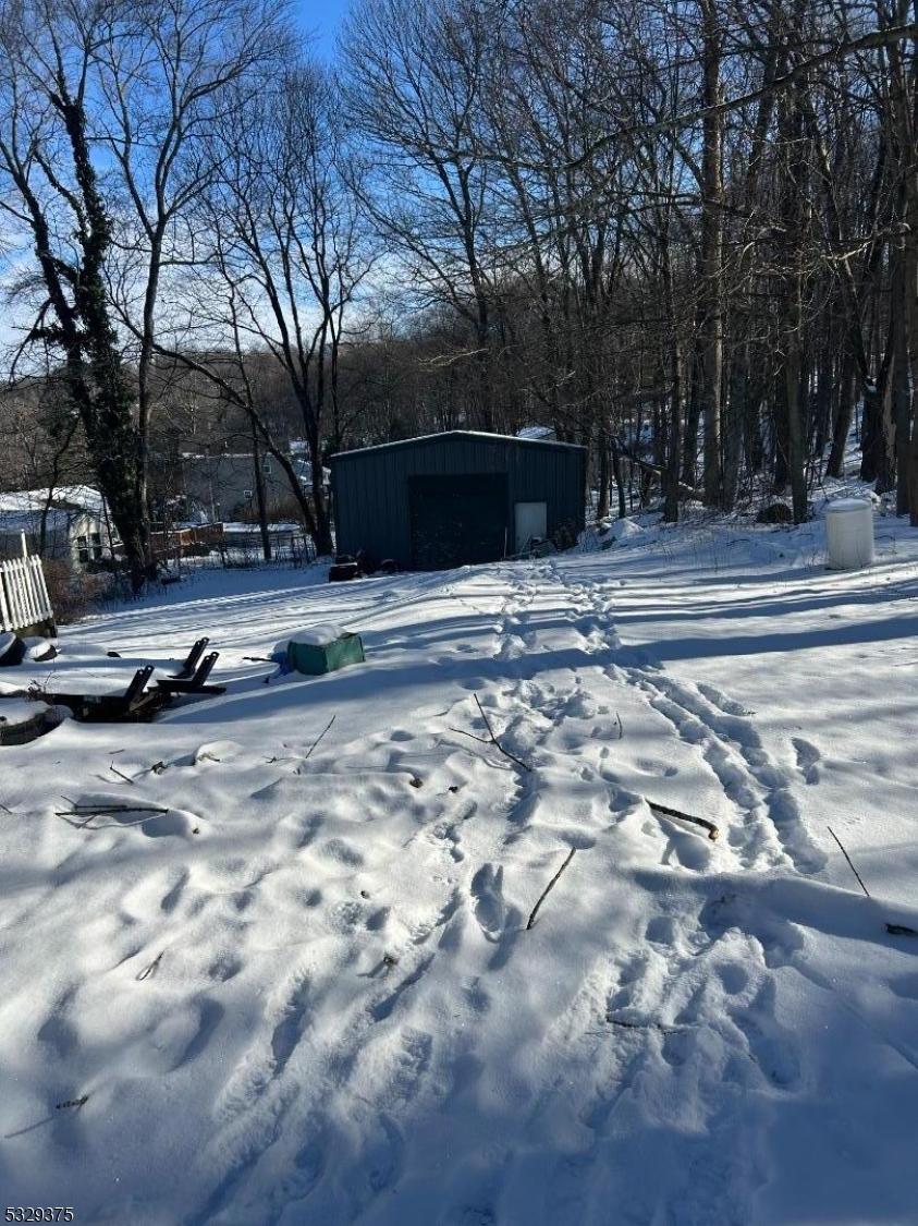 snowy yard featuring an outdoor structure