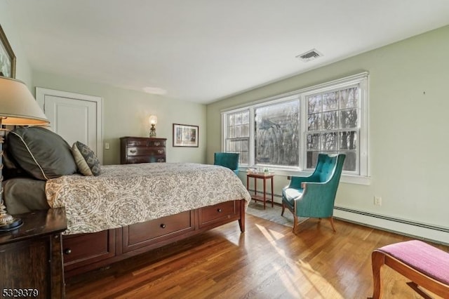 bedroom with wood-type flooring and a baseboard radiator