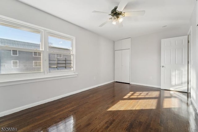 unfurnished bedroom with a closet, ceiling fan, and dark hardwood / wood-style flooring