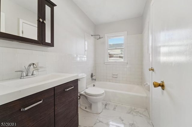 full bathroom with vanity, tiled shower / bath combo, toilet, and tile walls