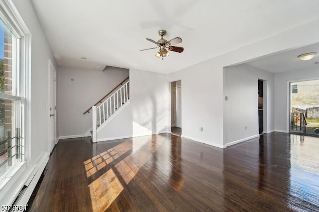 unfurnished living room with a baseboard radiator, plenty of natural light, dark wood-type flooring, and ceiling fan