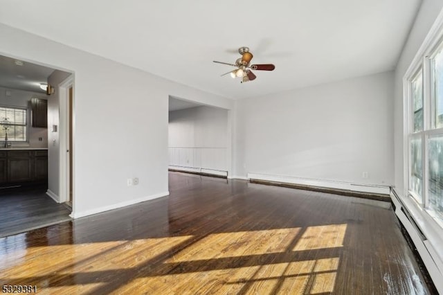 spare room with dark hardwood / wood-style flooring and a baseboard heating unit