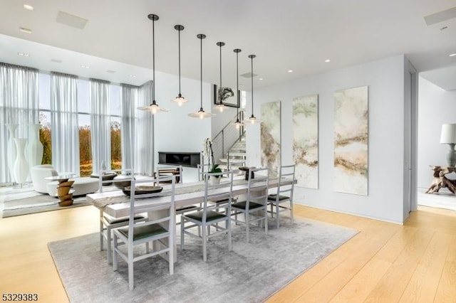 dining space with expansive windows and light hardwood / wood-style floors