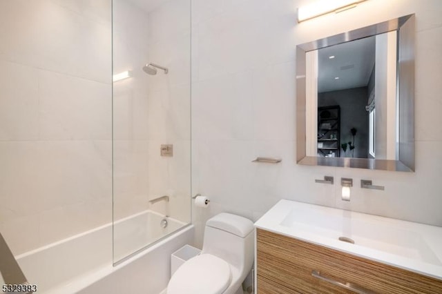 full bathroom featuring vanity, tiled shower / bath combo, and toilet