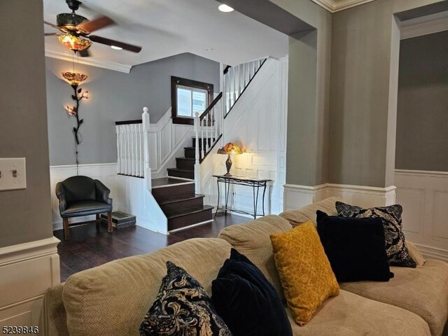 living room featuring dark hardwood / wood-style floors, ceiling fan, and crown molding