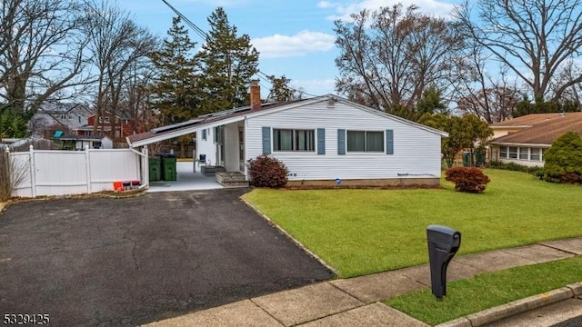 ranch-style house featuring a carport and a front lawn