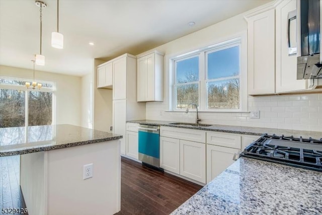 kitchen with sink, white cabinetry, hanging light fixtures, stainless steel appliances, and dark hardwood / wood-style floors