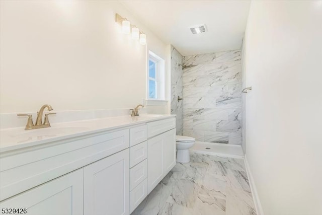 bathroom featuring vanity, toilet, and a tile shower