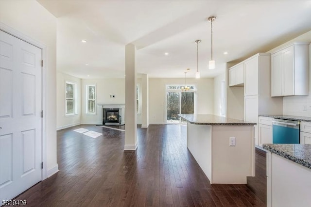 kitchen with stone counters, dark hardwood / wood-style floors, decorative light fixtures, white cabinetry, and stainless steel dishwasher