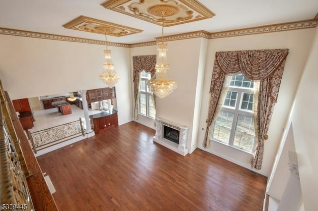 living room with a high end fireplace, crown molding, a wealth of natural light, and dark wood-type flooring