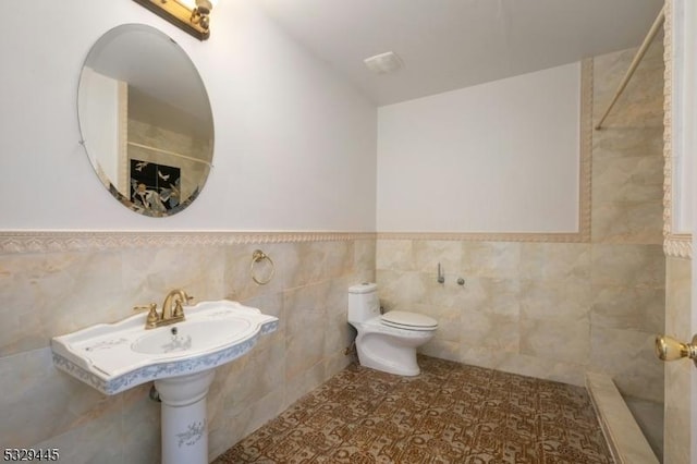 bathroom with walk in shower, tile walls, and toilet