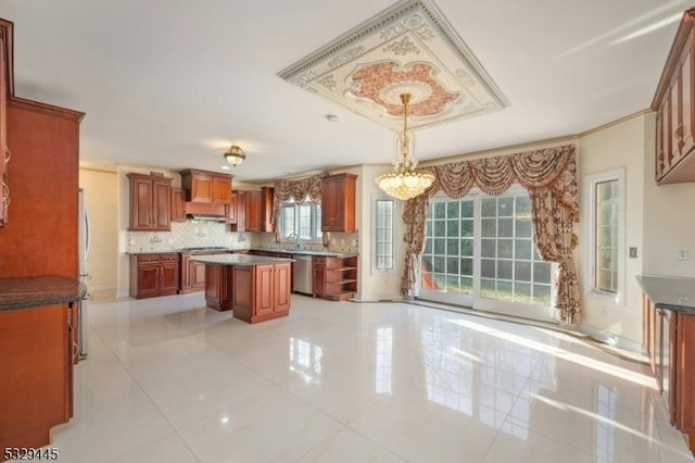 kitchen featuring tasteful backsplash, light tile patterned floors, decorative light fixtures, dishwasher, and a kitchen island