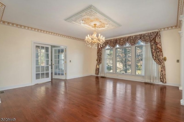 spare room featuring hardwood / wood-style floors and a chandelier