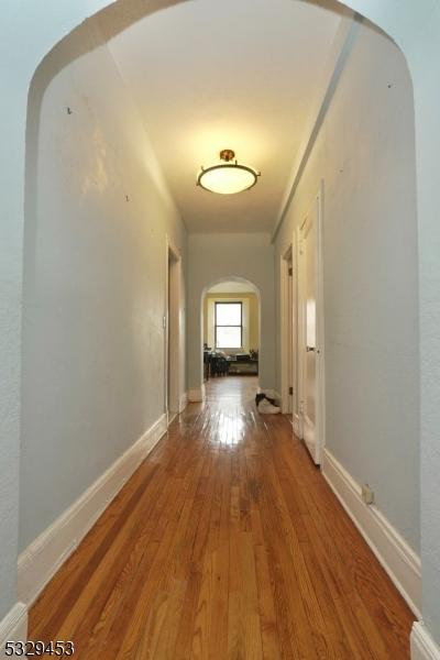 hallway with hardwood / wood-style floors