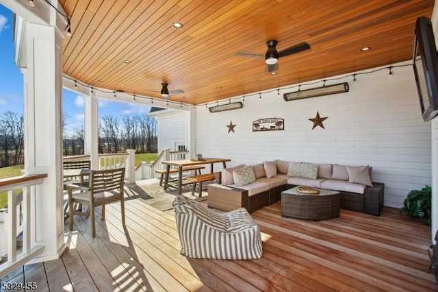 wooden terrace with an outdoor living space and ceiling fan