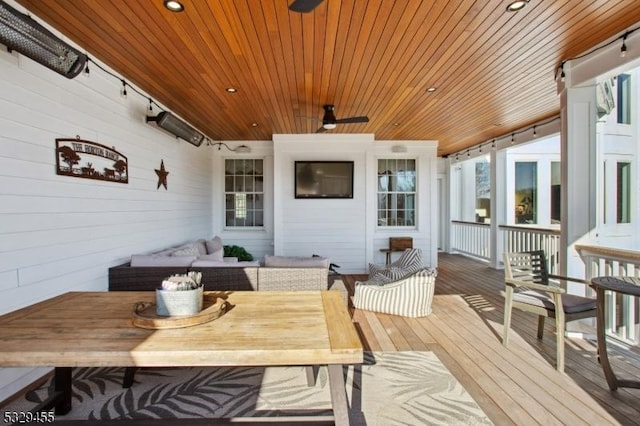 wooden terrace with ceiling fan and an outdoor living space