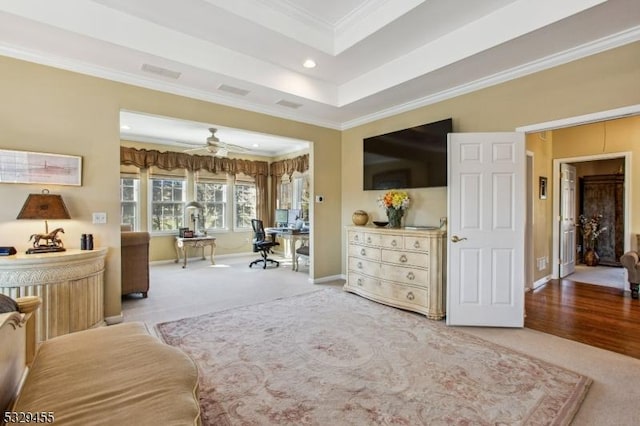 carpeted bedroom featuring ornamental molding and a tray ceiling