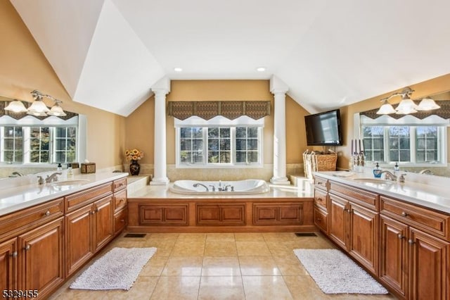 bathroom featuring a bathtub, vanity, lofted ceiling, and tile patterned flooring