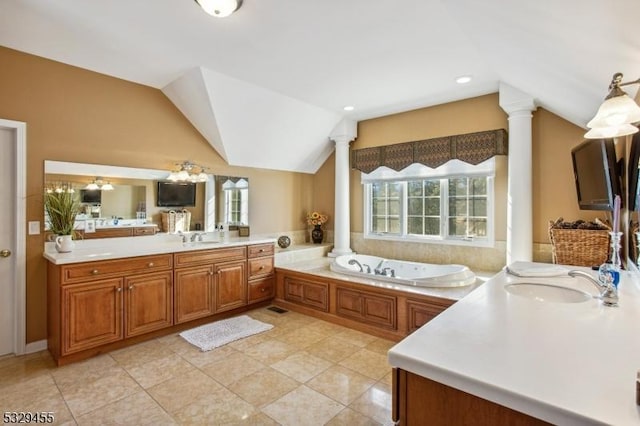 bathroom with decorative columns, vanity, a healthy amount of sunlight, and vaulted ceiling