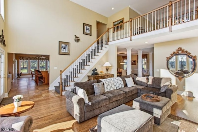 living room featuring a high ceiling, decorative columns, and french doors