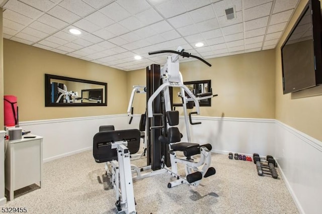 exercise area with light carpet and a drop ceiling