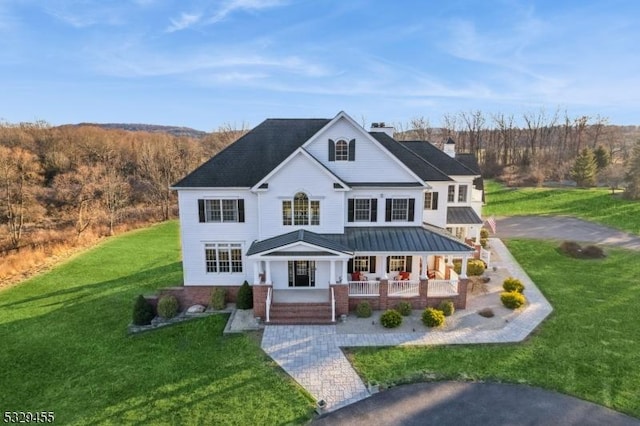 view of front of home with a porch and a front lawn