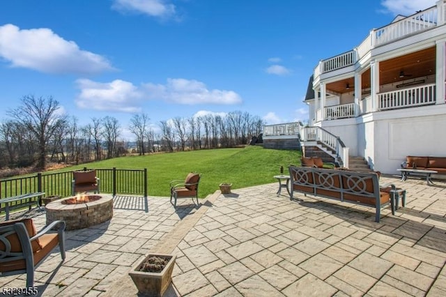 view of patio featuring a balcony, a fire pit, and ceiling fan