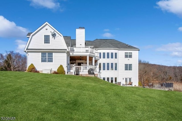 rear view of property featuring a yard and a balcony