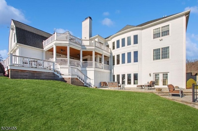 back of house with french doors, a balcony, a patio, ceiling fan, and a yard