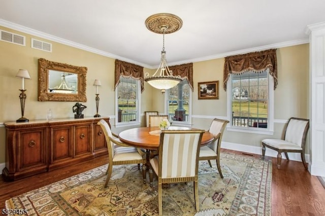 dining area with dark hardwood / wood-style floors and crown molding