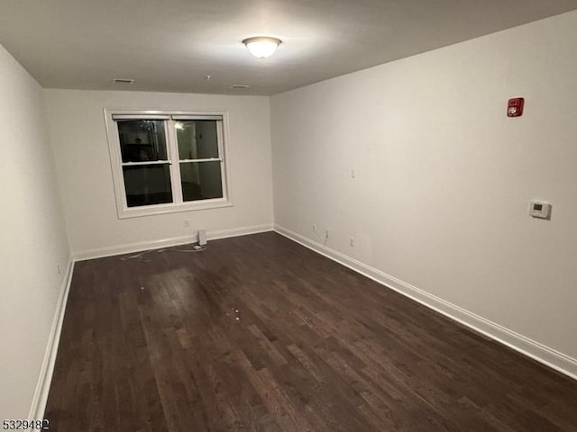 spare room with dark hardwood / wood-style flooring