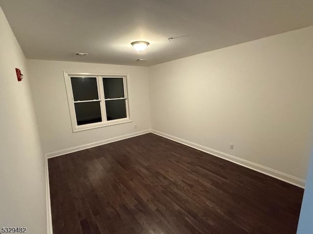 spare room with dark hardwood / wood-style flooring