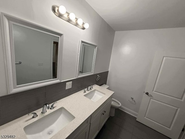 bathroom featuring tasteful backsplash, vanity, tile patterned floors, and toilet