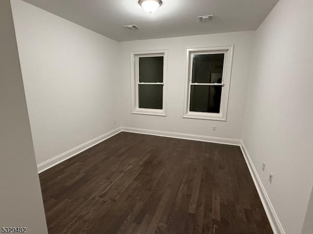 unfurnished room with dark hardwood / wood-style flooring