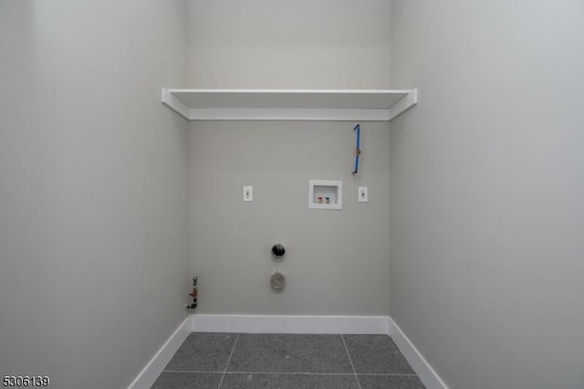 laundry area featuring dark tile patterned flooring, hookup for a gas dryer, and hookup for a washing machine