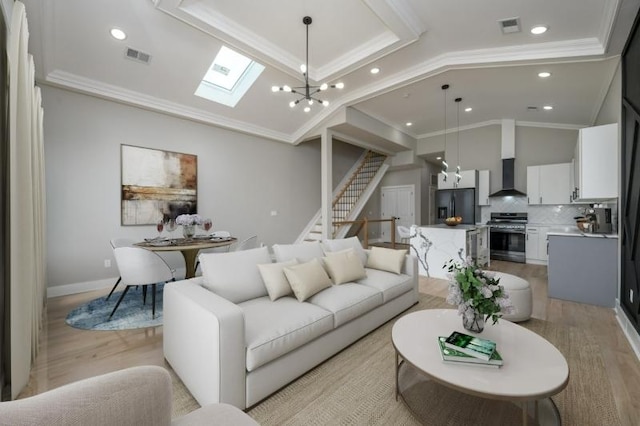 living room featuring ornamental molding, light wood-type flooring, and a notable chandelier