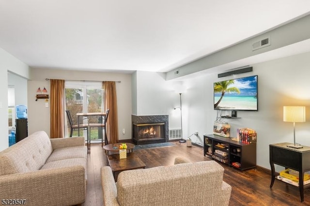 living room with dark wood-type flooring and a premium fireplace