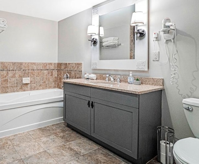 bathroom featuring vanity, toilet, and a tub