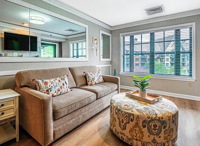 living room with hardwood / wood-style floors, a wealth of natural light, and ornamental molding