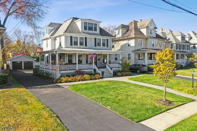 view of front of house with a porch, a garage, an outdoor structure, and a front yard