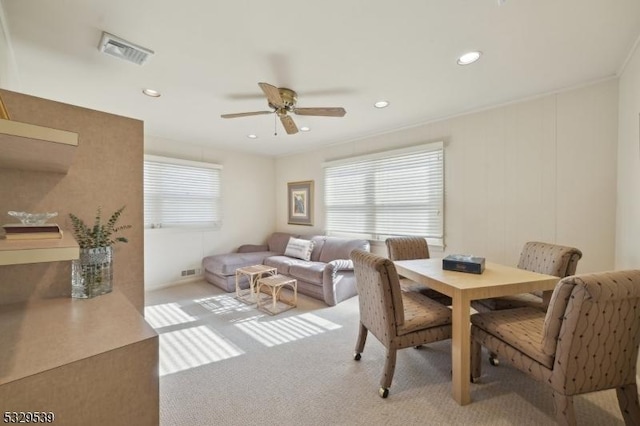 carpeted dining space with a healthy amount of sunlight and ceiling fan