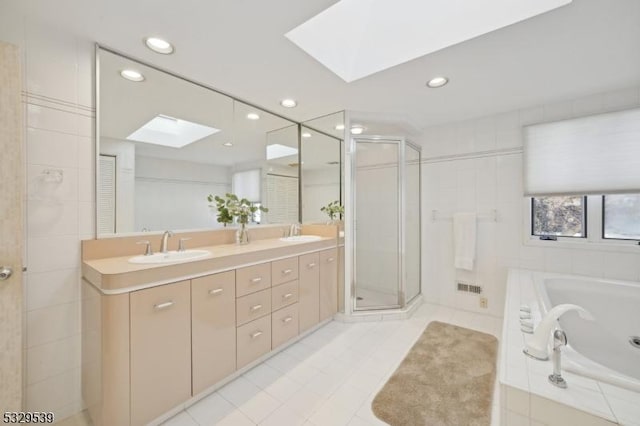 bathroom with vanity, a skylight, and plus walk in shower