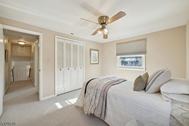 bedroom with ceiling fan, a closet, and light carpet