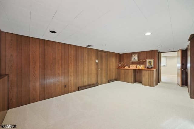 interior space with light carpet and wood walls