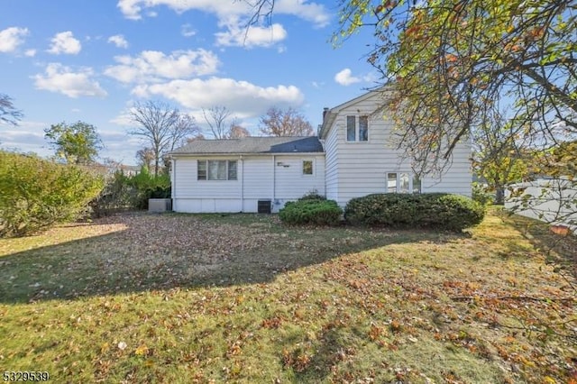 rear view of property featuring a lawn