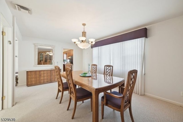 dining room with an inviting chandelier and light carpet