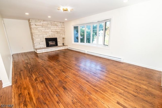 unfurnished living room with a fireplace, a baseboard heating unit, and hardwood / wood-style flooring