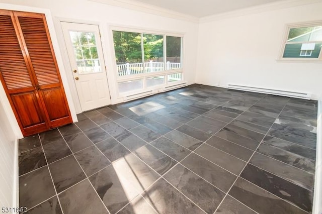 empty room featuring crown molding and a baseboard heating unit