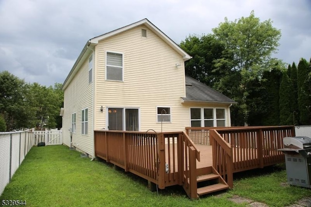 rear view of property with a deck, a yard, and a fenced backyard