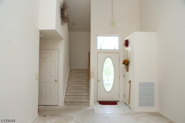 foyer entrance featuring stairs and a high ceiling